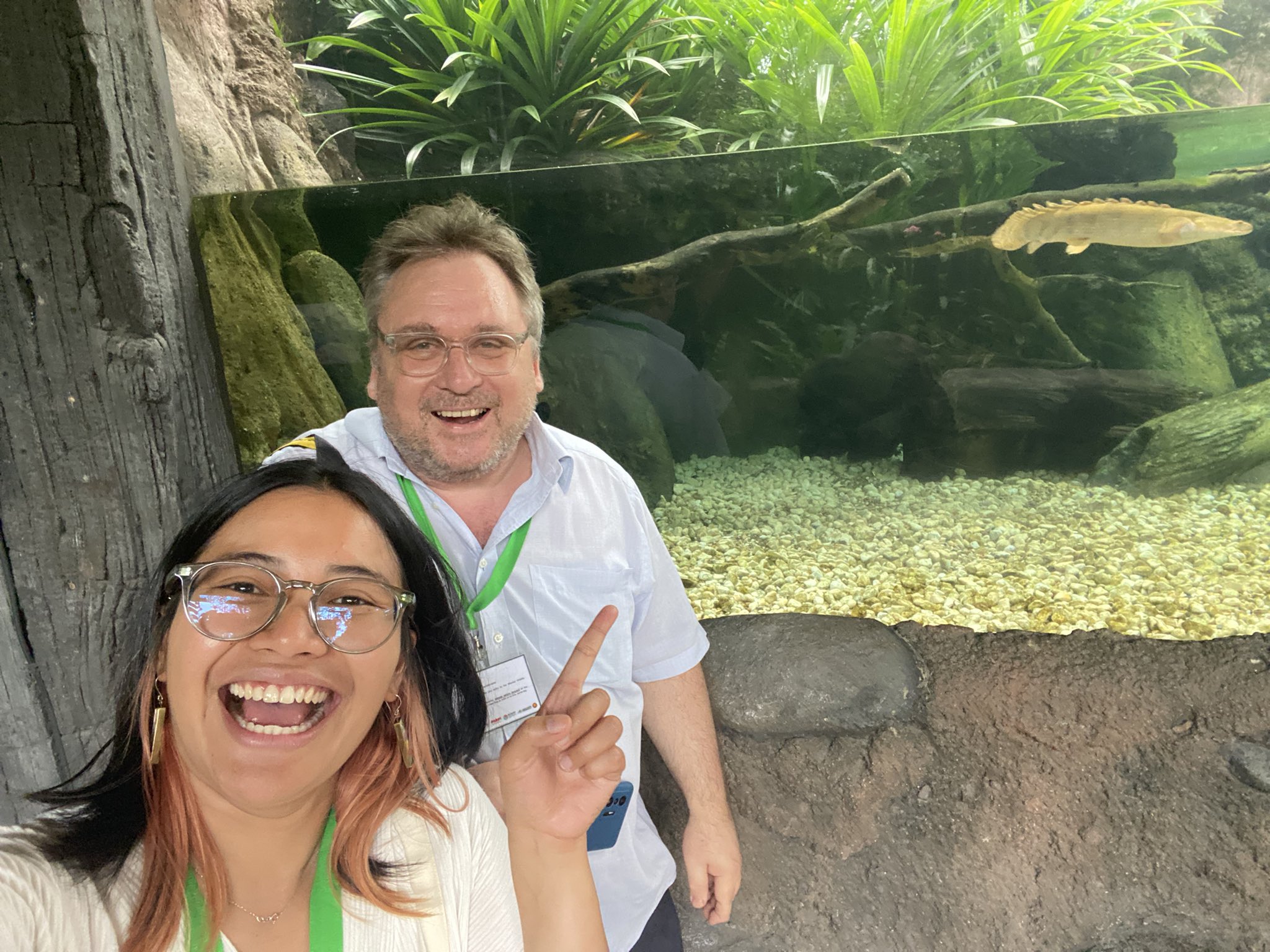 A photograph of a man and a woman in front of an aquarium. Conservation southeast asia.